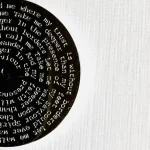 black Kings of Leon Use Somebody lyric necklace displayed on stand minimalist background